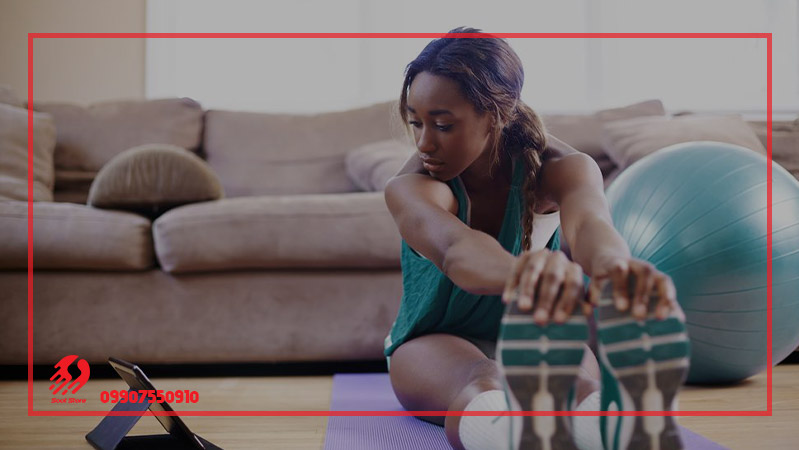 زنی در حال انجام ورزش انلاین در خانه